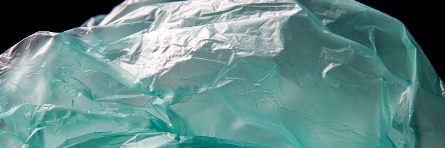 Blue plastic waste on black background, symbolizing the shift toward biodegradable alternatives
