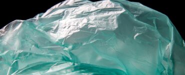 Blue plastic waste on black background, symbolizing the shift toward biodegradable alternatives