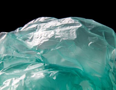 Blue plastic waste on black background, symbolizing the shift toward biodegradable alternatives